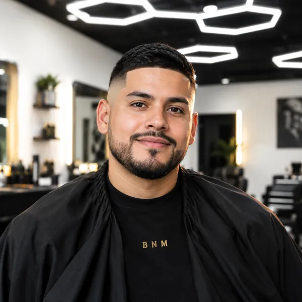 Marco, smiling in a black BNM cape.